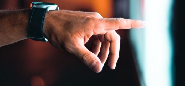 Hand wearing a watch pointing