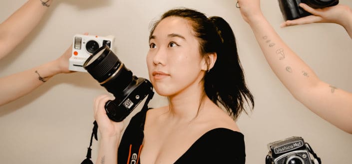 Woman holding a camera while looking up