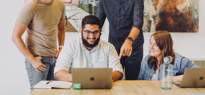Group of people pointing at laptop