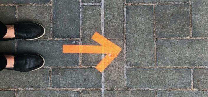 Foot beside an arrow on floor